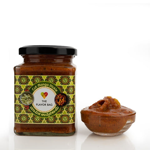 The Flavor Bag Cut Mango Pickle in a glass jar with a small bowl of pickle. Traditional South Indian recipe.