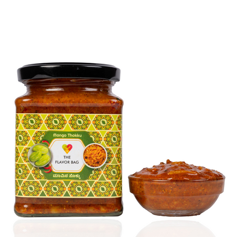 The Flavor Bag Mango Thokku in a glass jar with a small bowl of the spicy South Indian mango chutney beside it.
