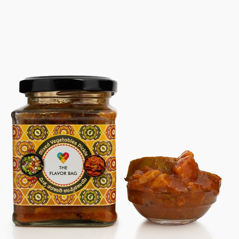 The Flavor Bag Mixed Vegetable Pickle in a glass jar with a small bowl of pickle. Authentic South Indian recipe.