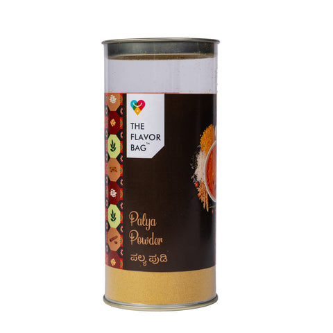 The Flavor Bag Palya Powder seasoning blend in a clear cylindrical container with a black label and spice graphics.