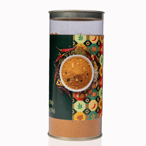 The Flavor Bag TN Style Sambar Powder in a clear cylindrical container with a vibrant spice-patterned label.
