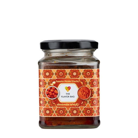 The Flavor Bag Tomato Pickle (Garlic) in a glass jar with a black lid, featuring a vibrant orange and red label with floral patterns.